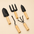 Set of gardening tools with black heads and wooden handles on a beige background